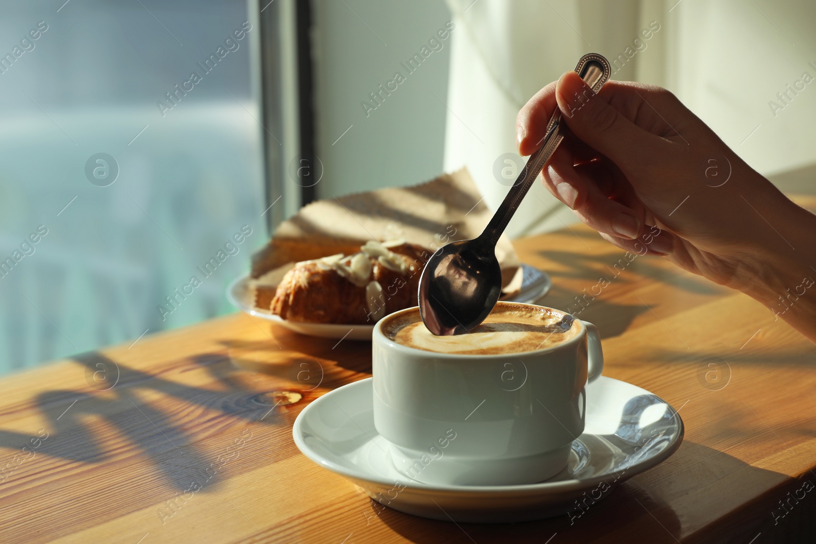 Photo of Woman with cup of fresh aromatic coffee at table in cafe