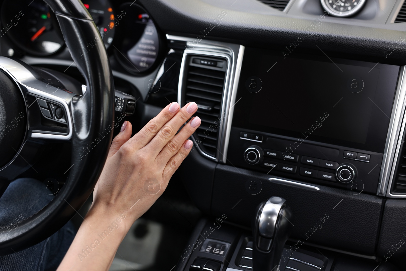 Photo of Woman checking air conditioner in her car, closeup