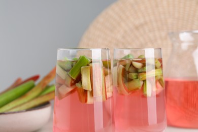 Glasses of tasty rhubarb cocktail on blurred background, closeup