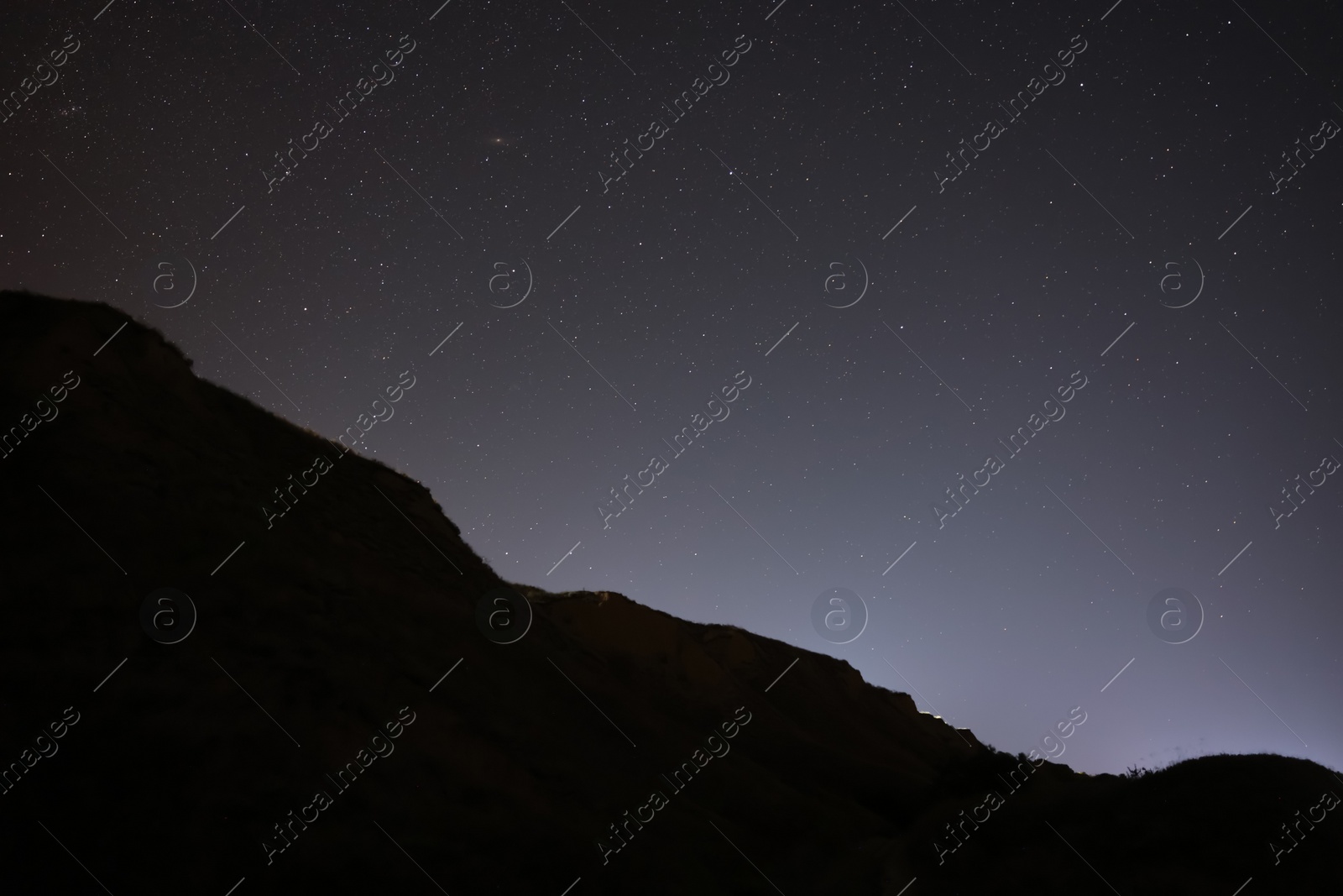 Photo of Picturesque view of starry sky at night over hill