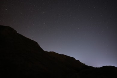 Picturesque view of starry sky at night over hill
