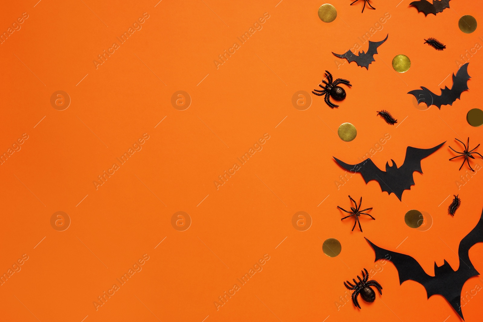 Photo of Flat lay composition with paper bats and spiders on orange background, space for text. Halloween decor