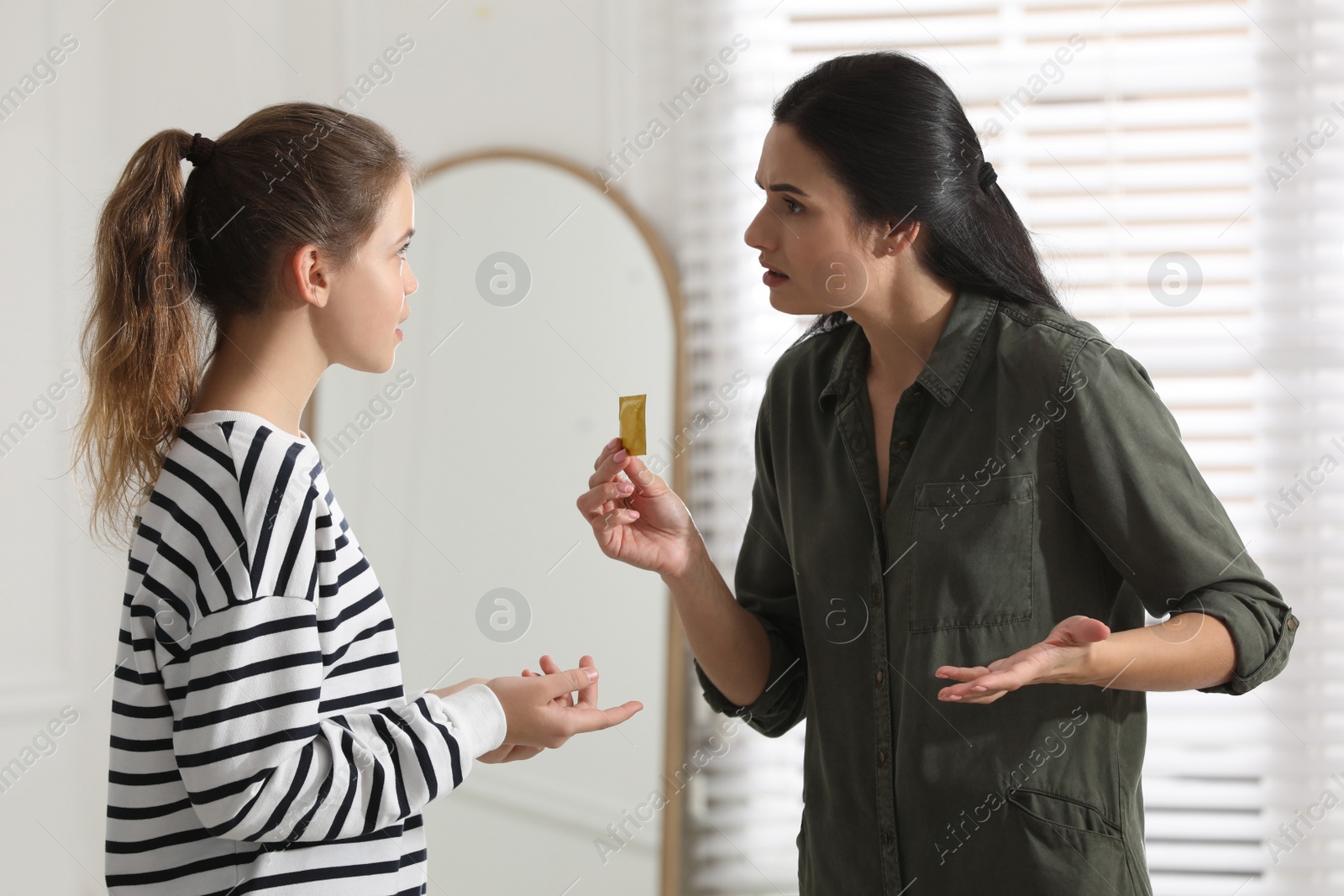 Photo of Mother talking with her teenage daughter about contraception at home. Sex education concept