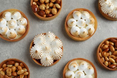 Many different tartlets on grey table, flat lay. Delicious dessert