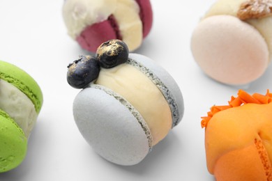 Photo of Delicious sweet macarons on white table, closeup