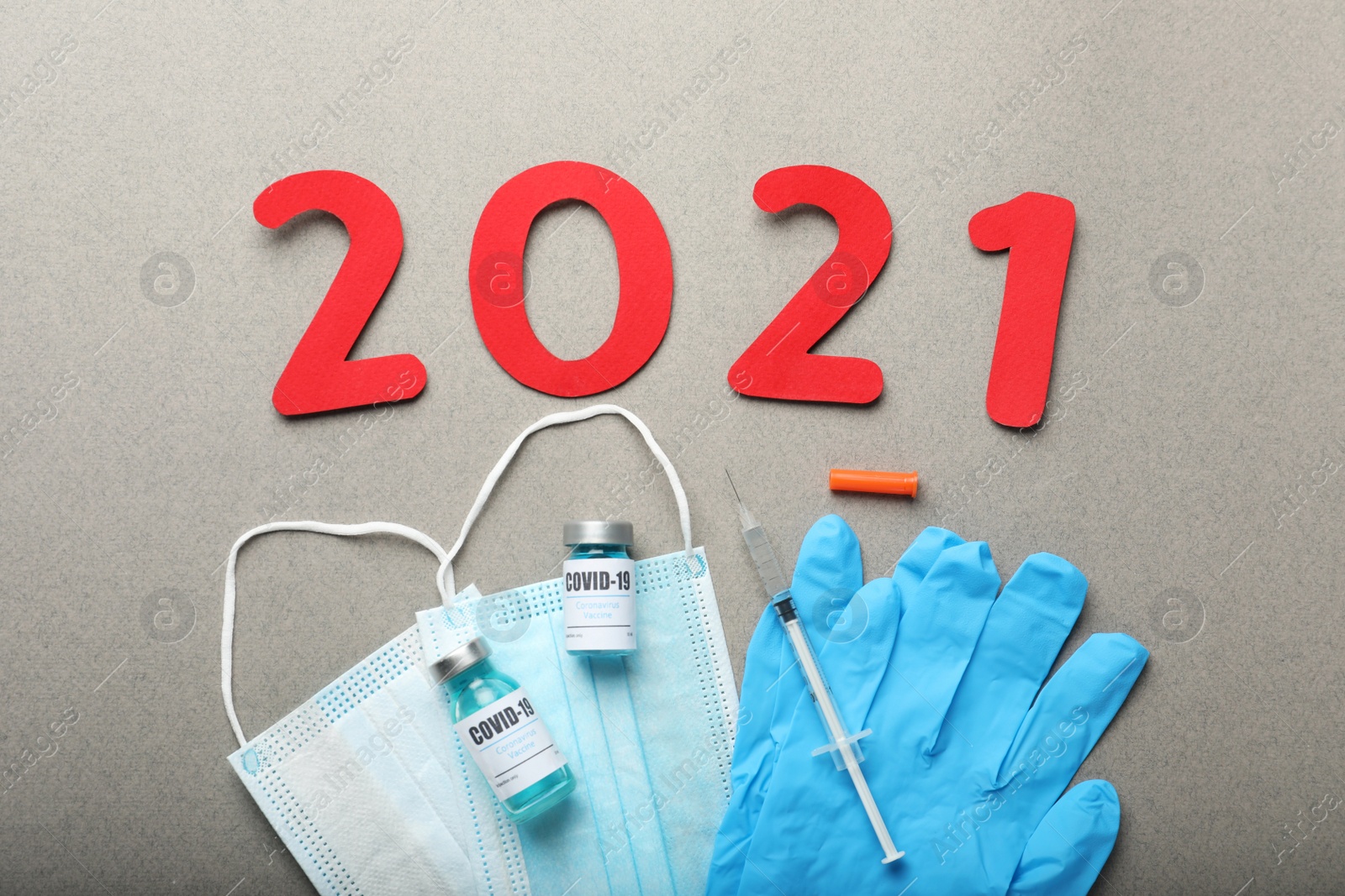 Photo of Flat lay composition with coronavirus vaccine and number 2021 on grey background