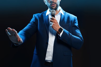 Photo of Motivational speaker with microphone performing on stage, closeup
