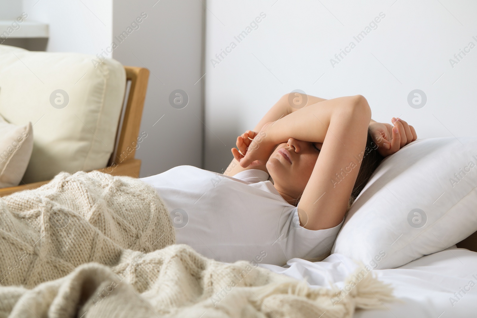 Photo of Sleepless young woman in bed at home