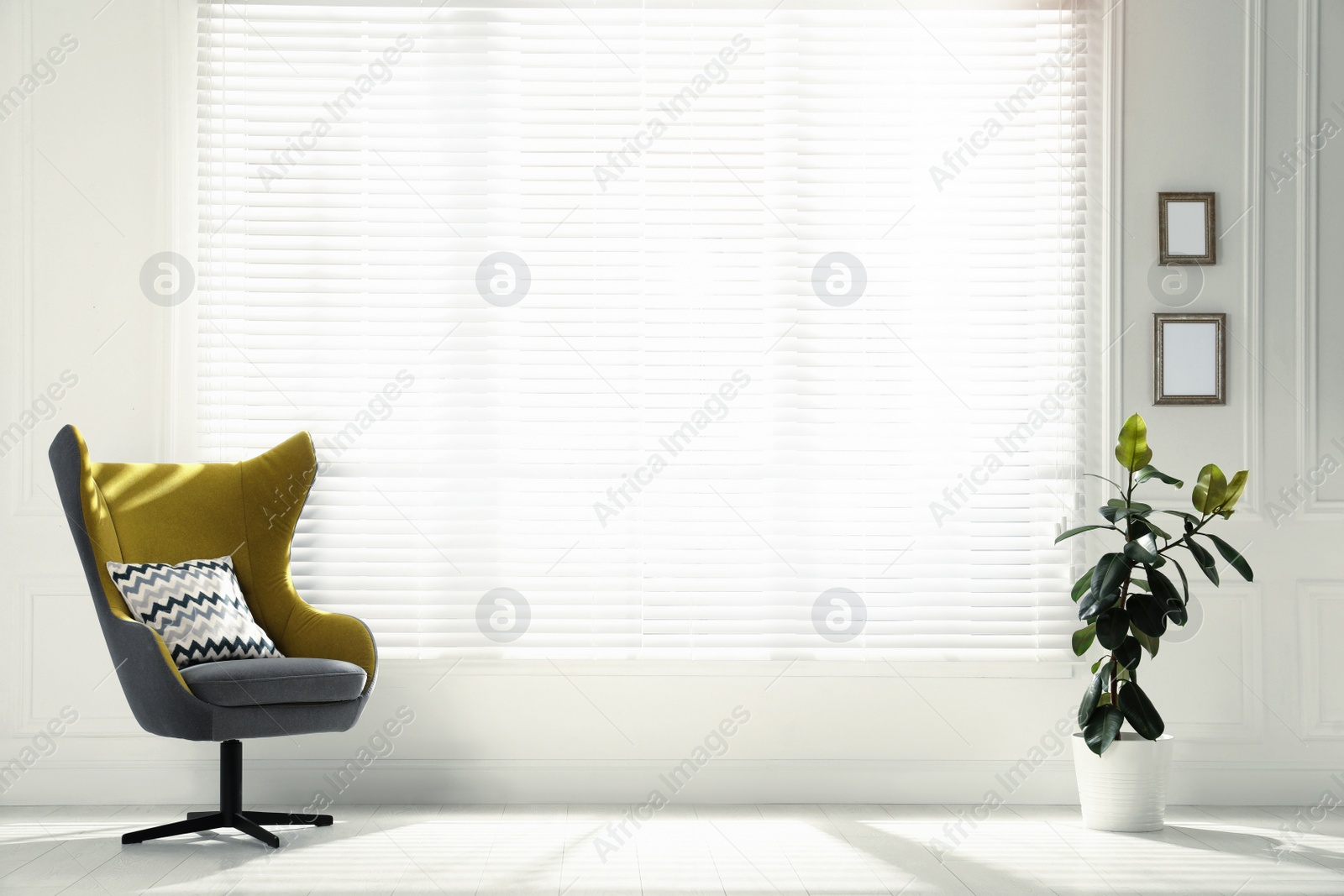 Photo of Comfortable armchair with pillow and plant near big window in spacious room. Interior design