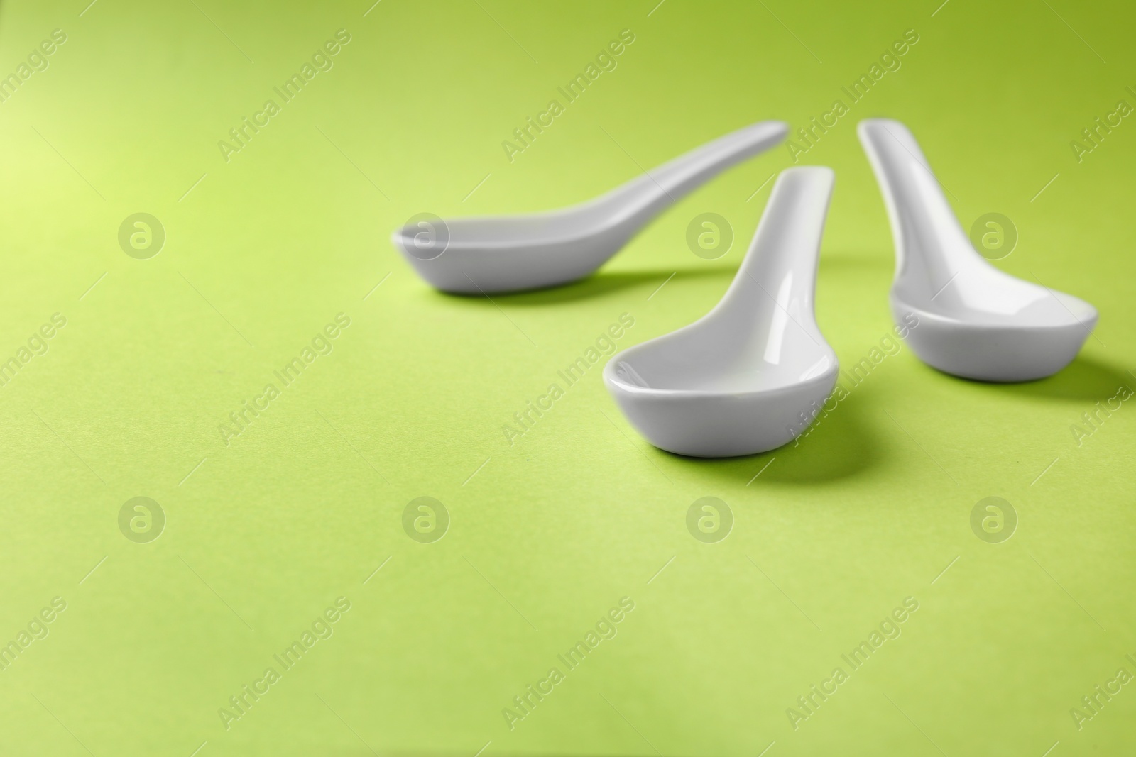 Photo of Miso soup spoons on green background. Space for text