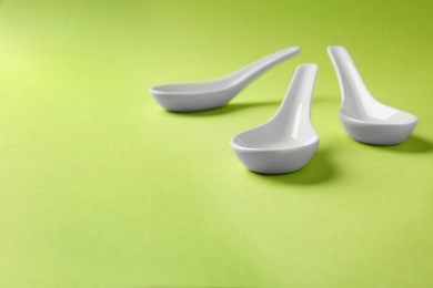 Miso soup spoons on green background. Space for text