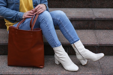 Woman in stylish leather shoes with bag on stairs outdoors, closeup