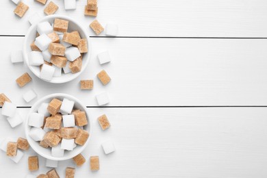 Photo of Different sugar cubes in bowls on white wooden table, flat lay. Space for text