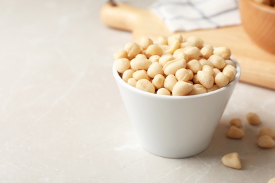 Photo of Shelled peanuts in bowl on table. Space for text