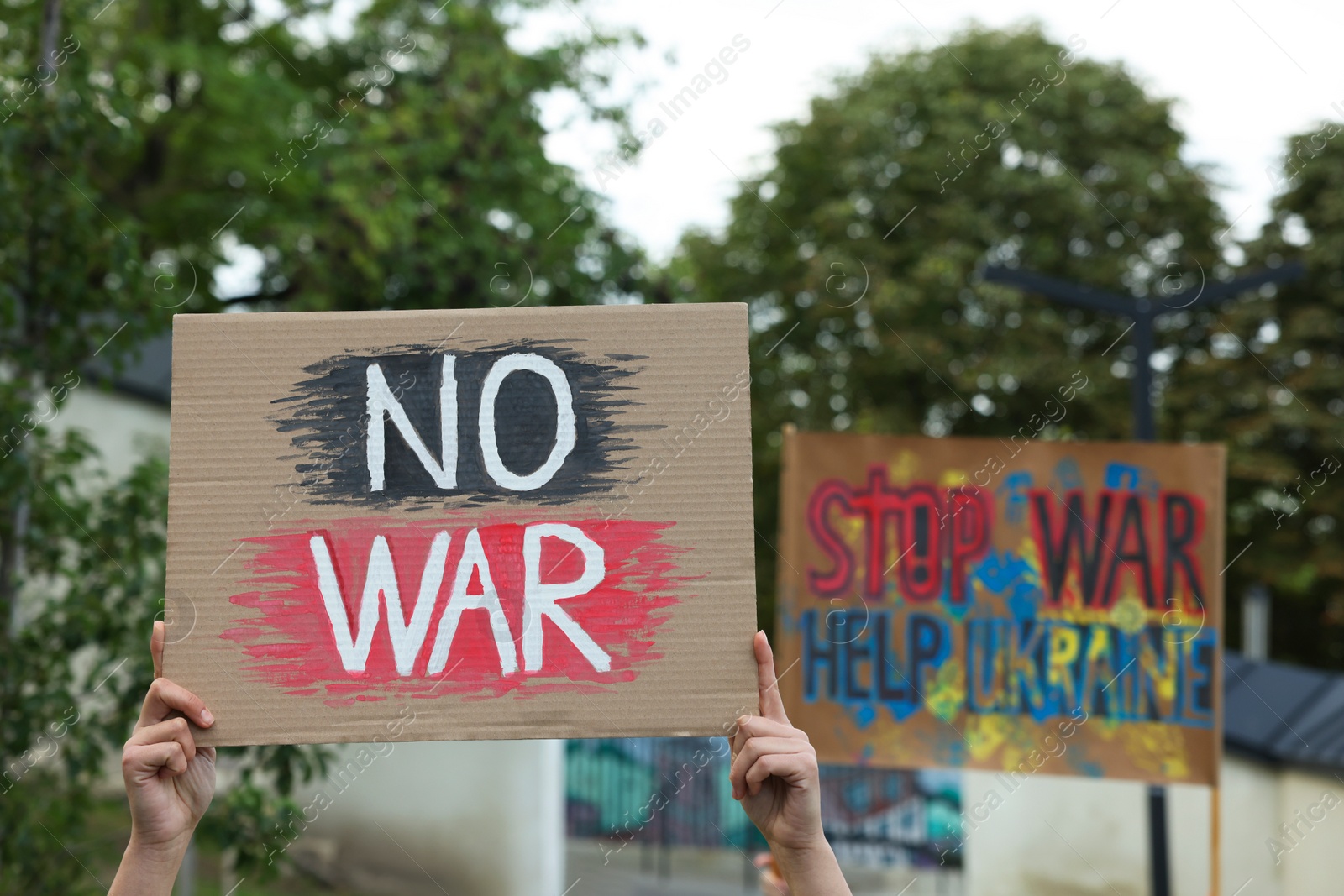 Photo of Woman holding poster with words No War outdoors, closeup