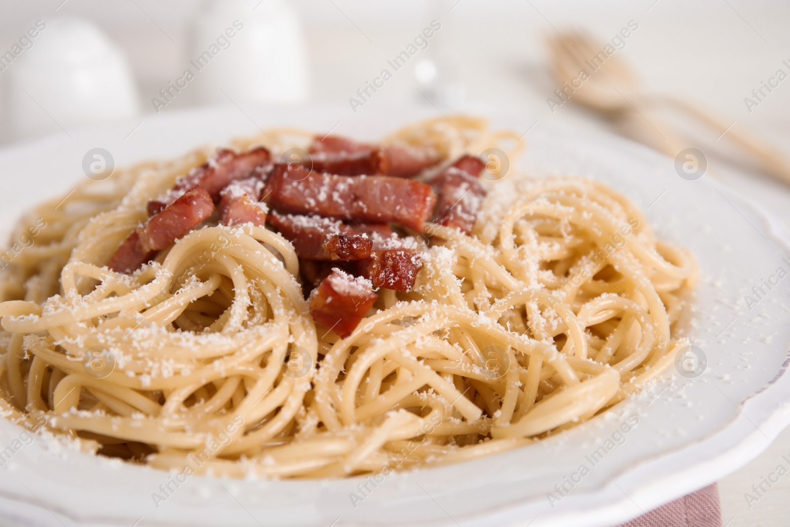 Photo of Delicious Carbonara pasta in plate on table, closeup