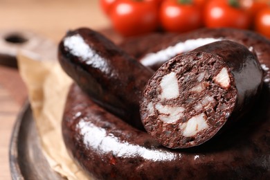 Photo of Tasty blood sausages served on board, closeup