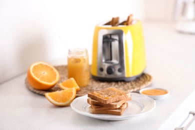 Photo of Modern toaster and delicious breakfast on table in kitchen