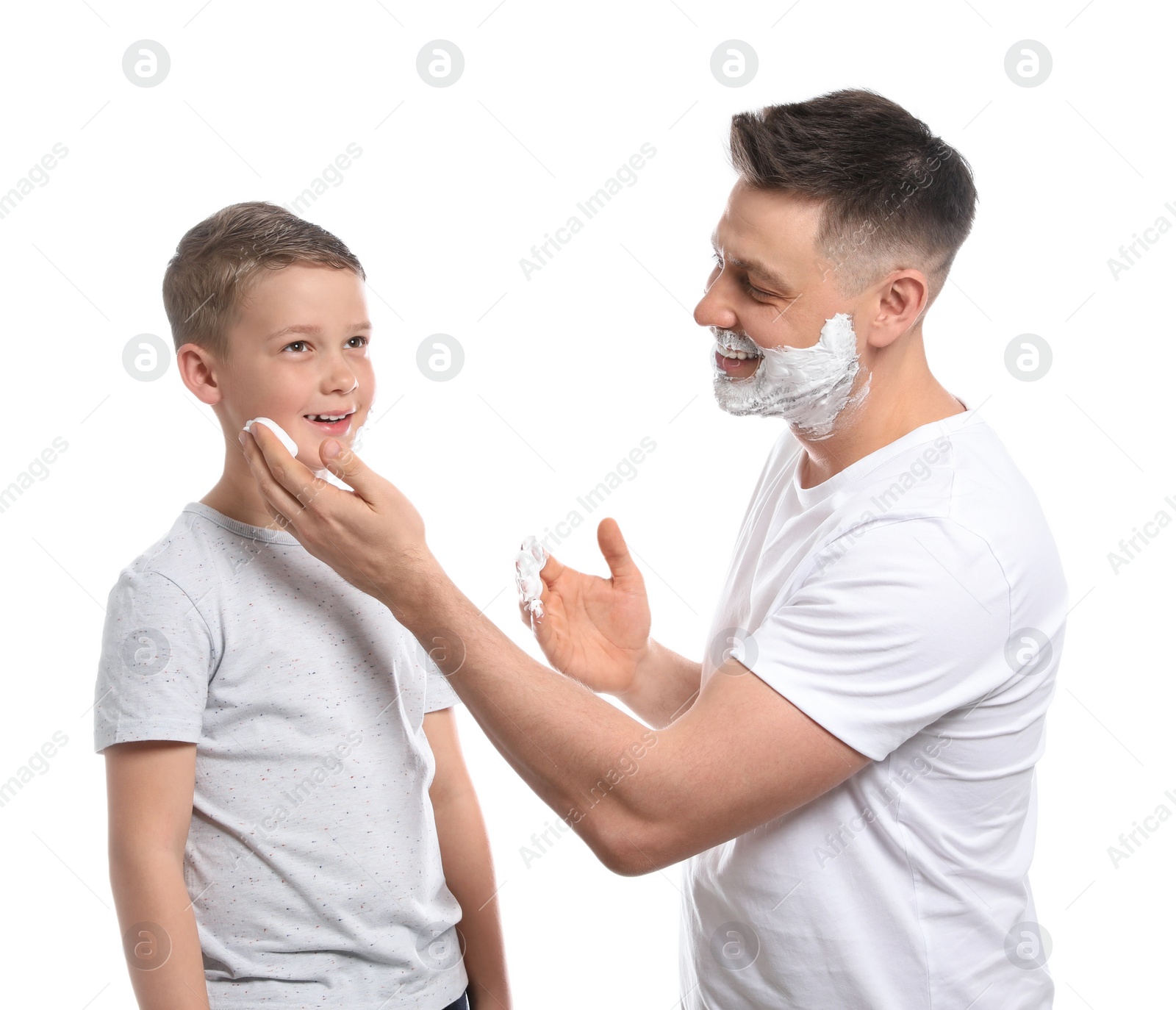 Photo of Dad applying shaving foam on son's face, white background