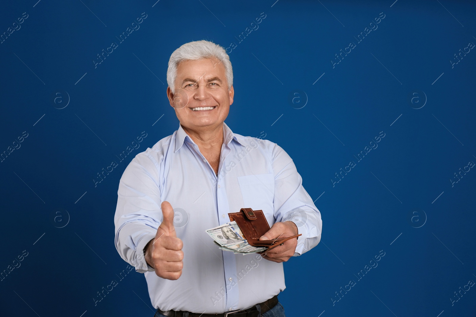 Photo of Happy senior man with cash money and wallet on blue background