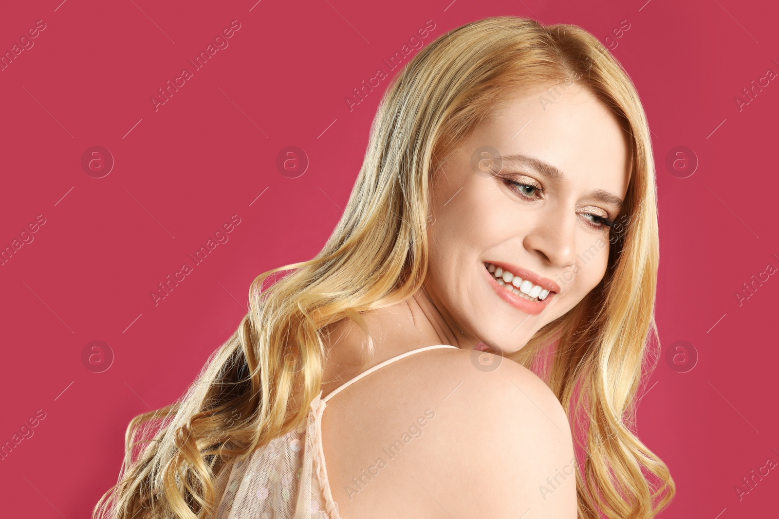 Photo of Portrait of beautiful young woman with dyed long hair on pink background