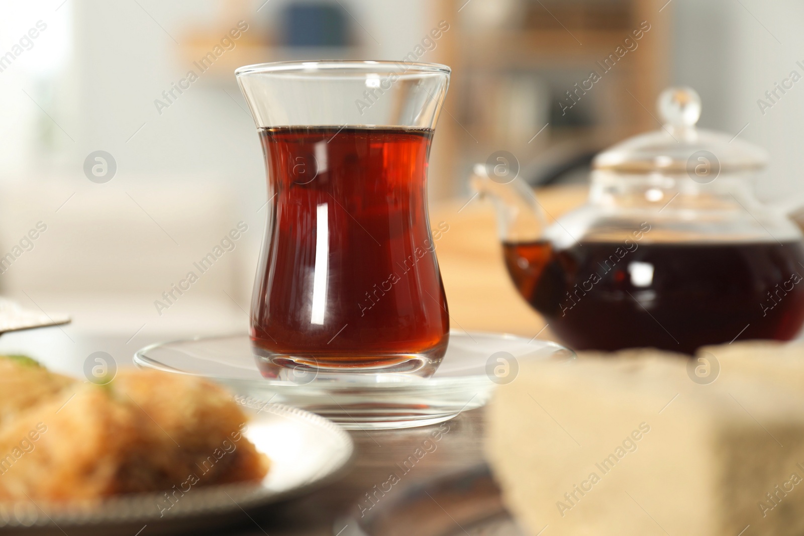 Photo of Cup of delicious Turkish tea served on wooden table, closeup