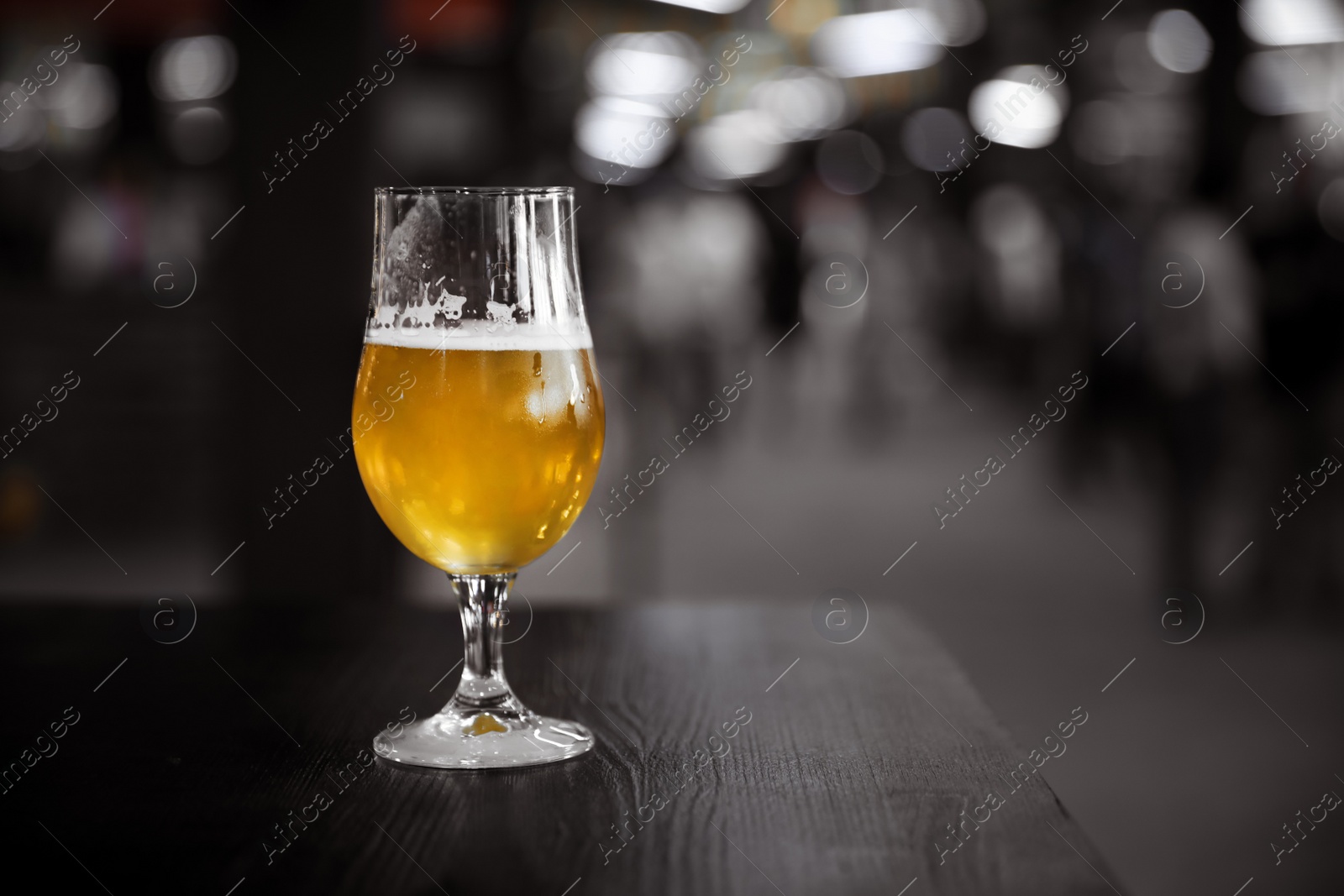 Photo of Cold tasty light beer on table in bar. Space for text