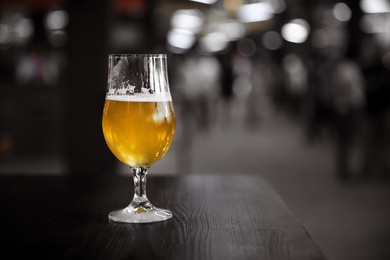 Cold tasty light beer on table in bar. Space for text