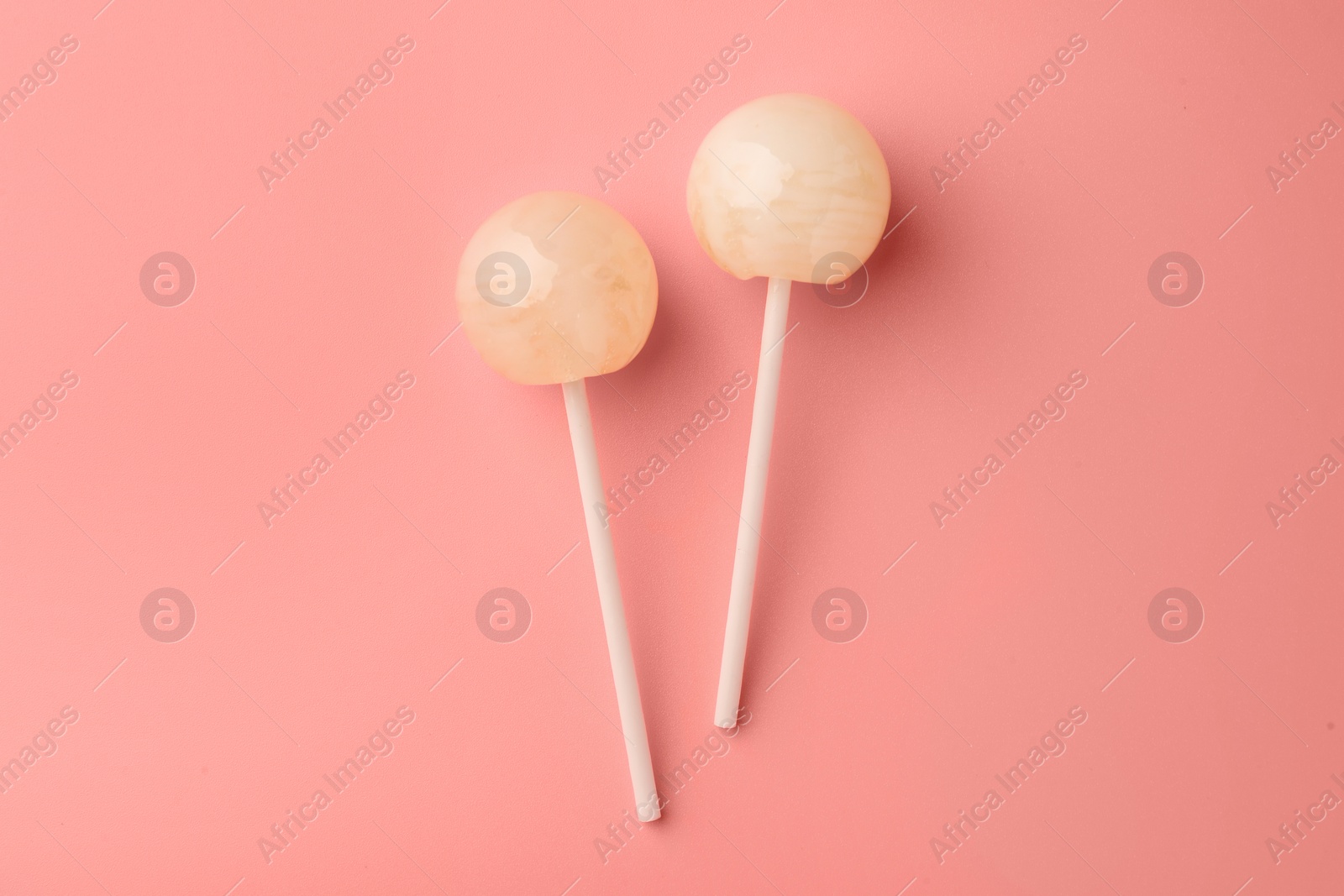 Photo of Tasty lollipops on pink background, flat lay