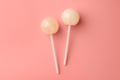 Tasty lollipops on pink background, flat lay