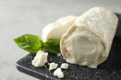 Delicious fresh goat cheese on black board, closeup