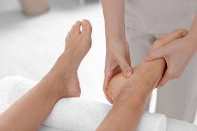 Woman receiving foot massage in wellness center, closeup