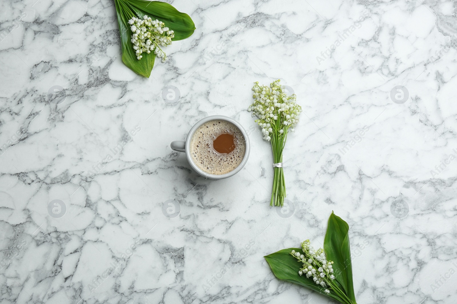 Photo of Flat lay composition with lily of the valley bouquets and coffee on marble background
