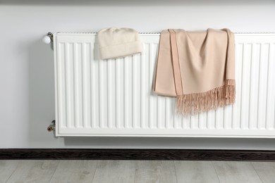 Photo of Hat and scarf on heating radiator indoors