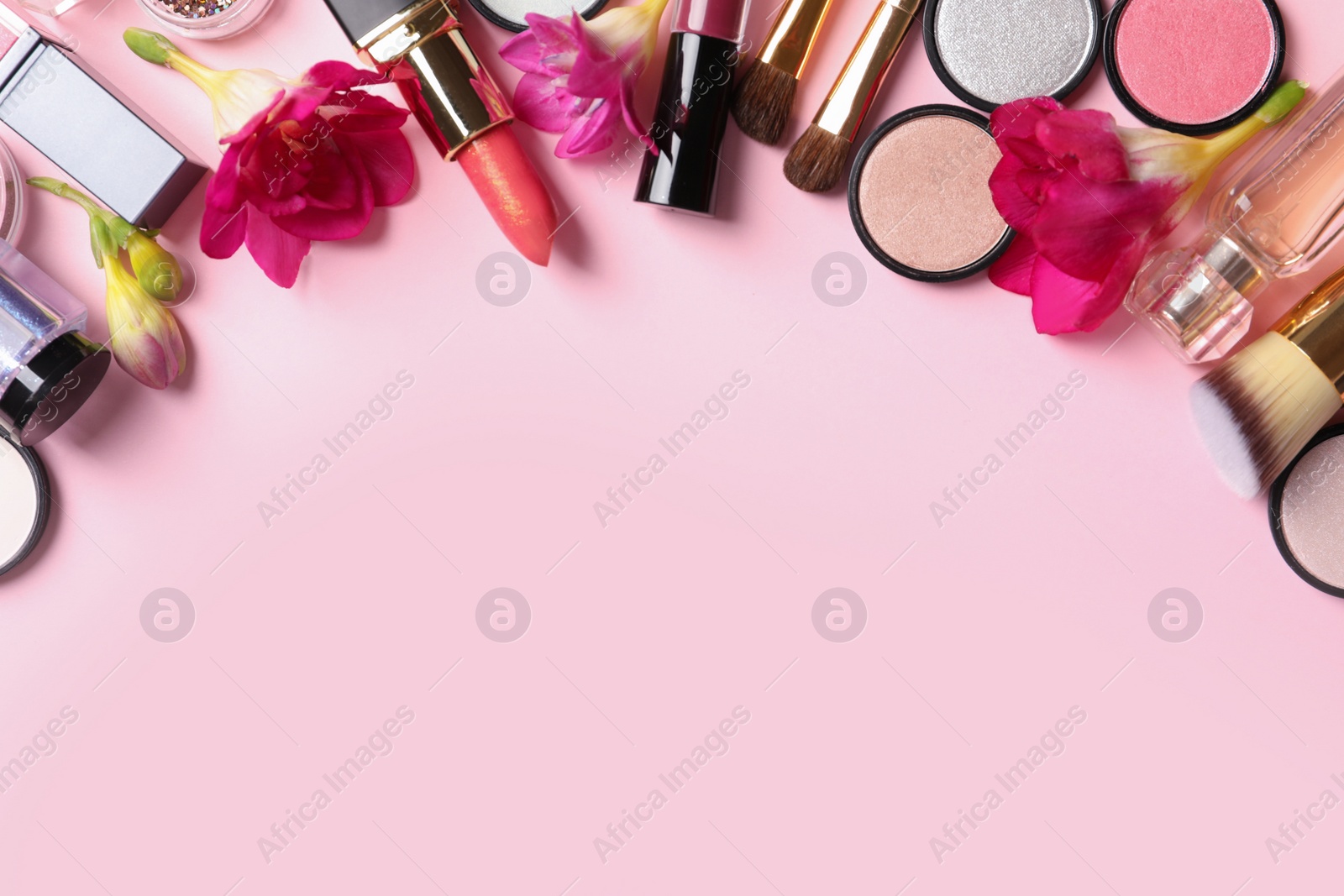 Photo of Frame made of different makeup products and flowers on color background. Space for text