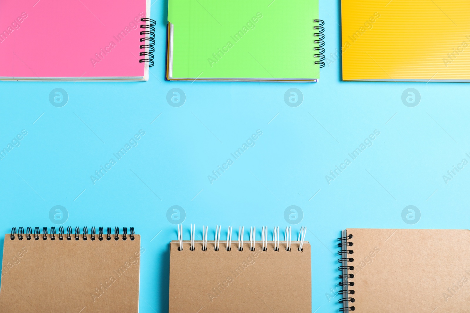 Photo of Flat lay composition with plastic and paper notebooks on light blue background, space for text. Recycling concept