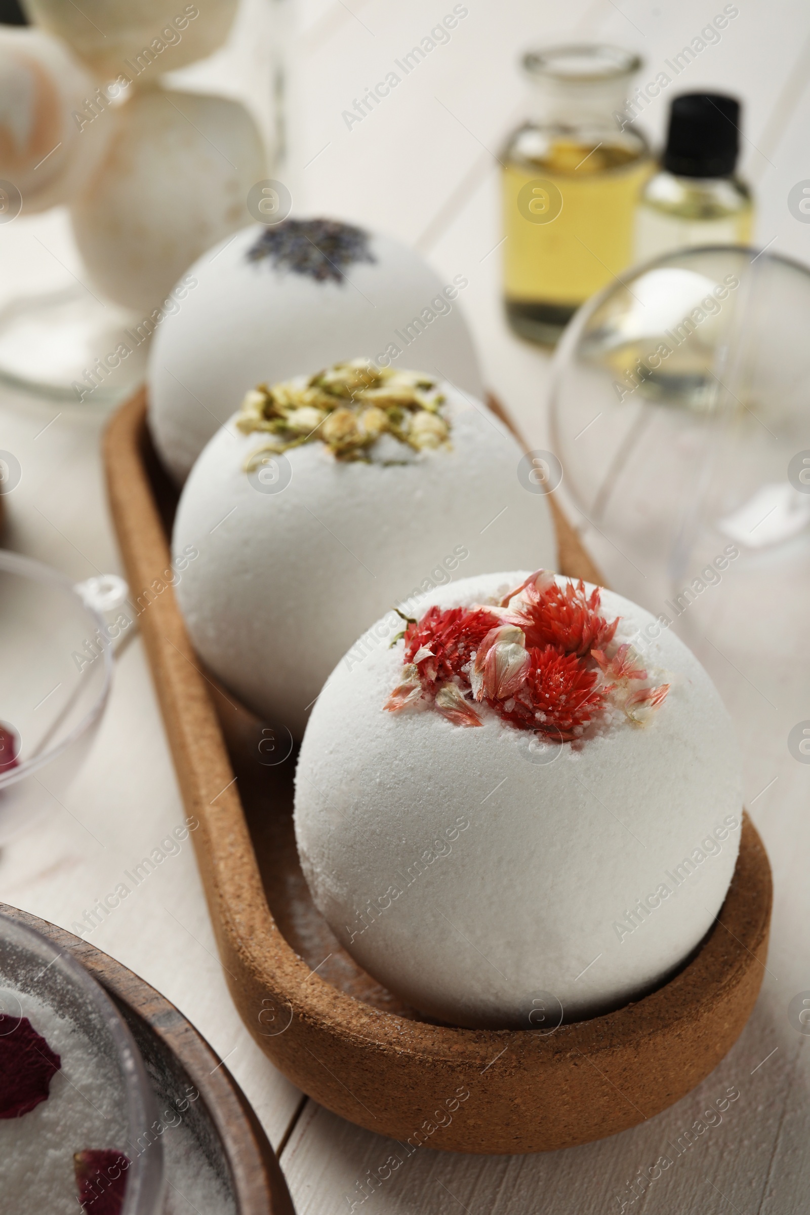 Photo of Tray with different bath bombs on white wooden table