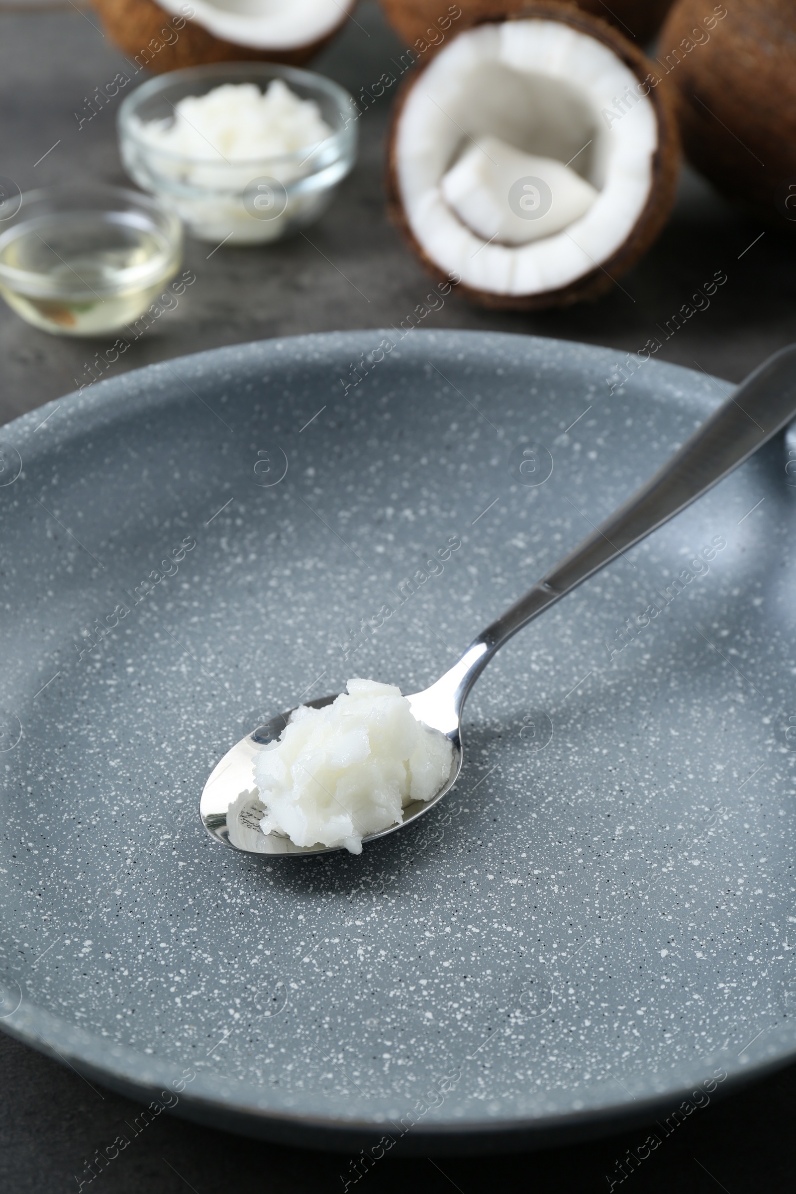 Photo of Frying pan with organic coconut cooking oil and spoon on table, closeup