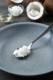 Frying pan with organic coconut cooking oil and spoon on table, closeup