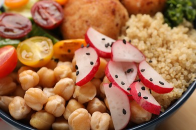 Delicious vegan bowl with chickpeas and radish on table, closeup