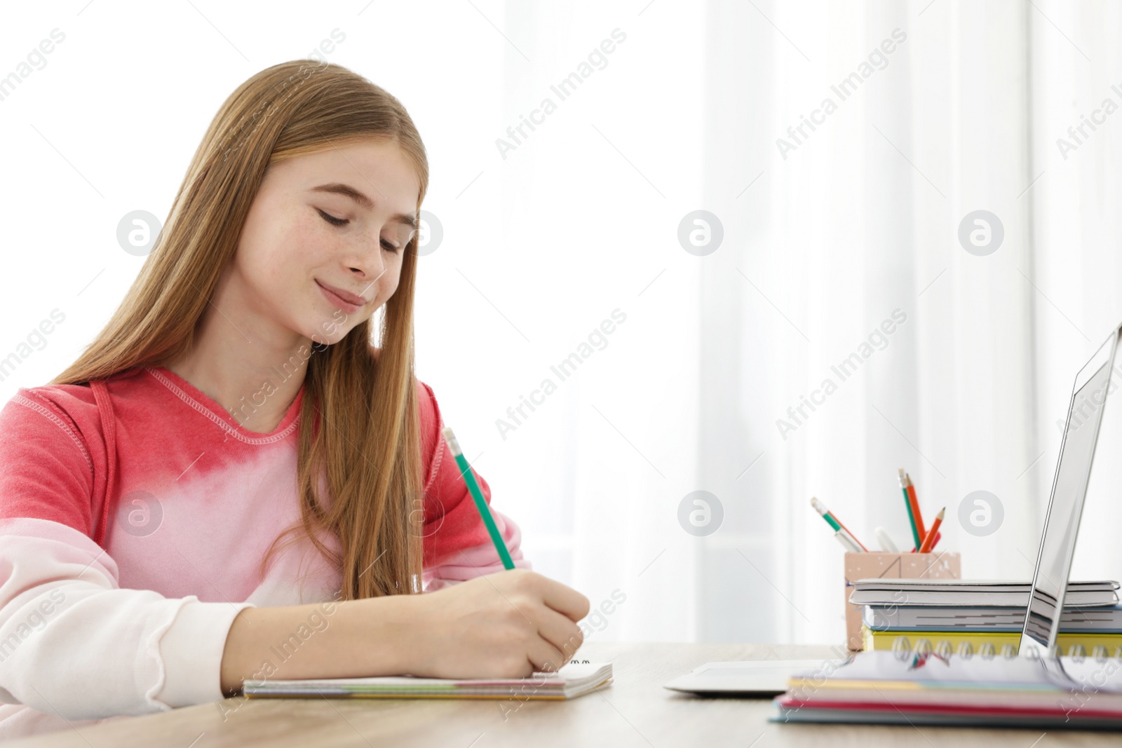 Photo of Teenager girl doing her homework at desk