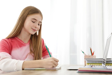 Teenager girl doing her homework at desk