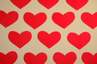 Small paper hearts on color background, top view