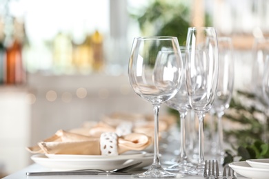 Photo of Table setting with empty glasses, plates and cutlery indoors