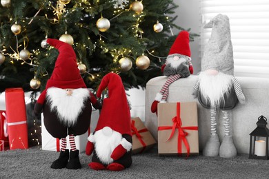Photo of Cute Scandinavian gnomes, Christmas tree and gift boxes in room