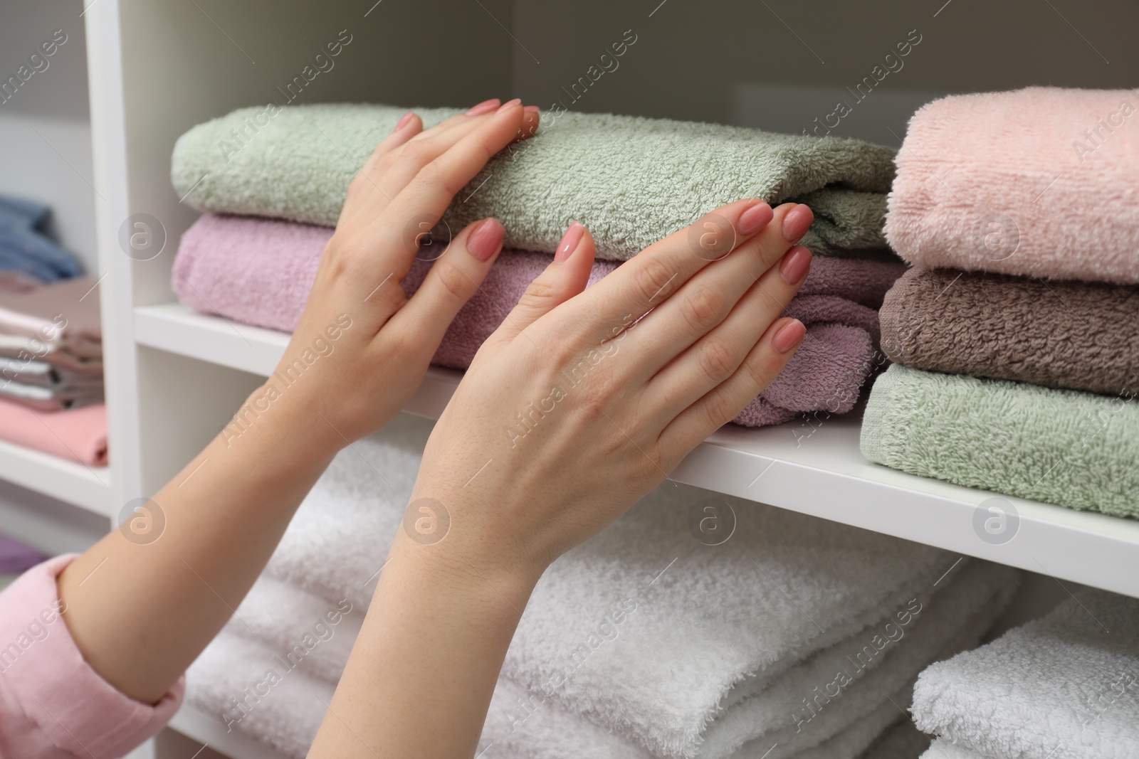 Photo of Customer choosing towels in linen shop, closeup