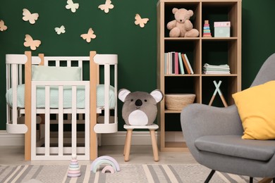 Photo of Beautiful baby room interior with comfortable crib and toys