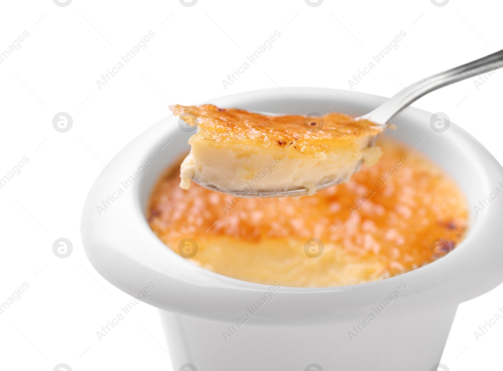 Photo of Taking delicious creme brulee with spoon from bowl on white background