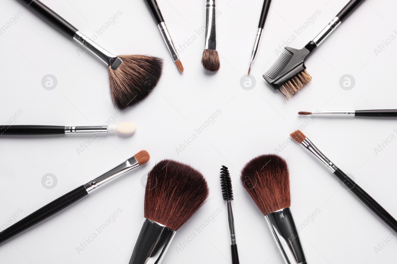 Photo of Frame of makeup brushes on white background, flat lay