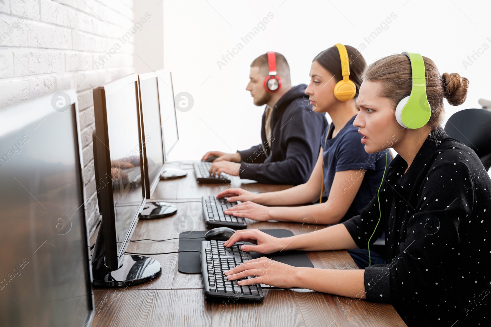 Photo of Young people playing video games on computers indoors. Esports tournament